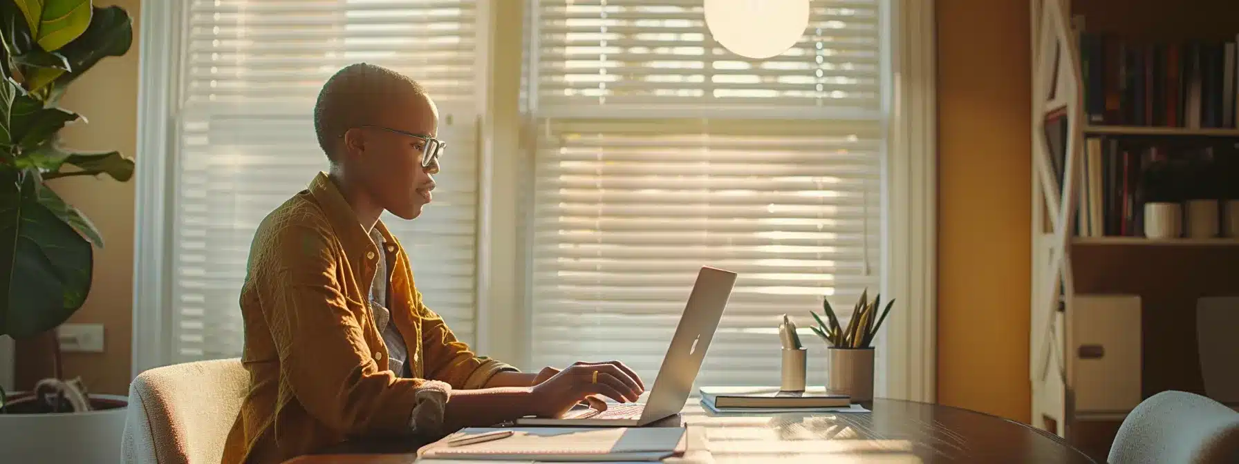 a person sitting at a desk with a laptop and notes, discussing homeowners insurance with an agent.